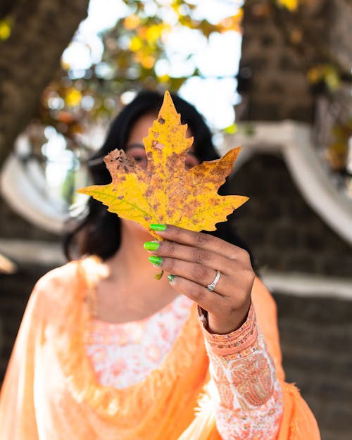 Autumn Maple Leaf Hold by a Woman with Green Nails