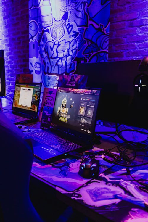 Gaming Laptops on a Desk in Purple Lighting 