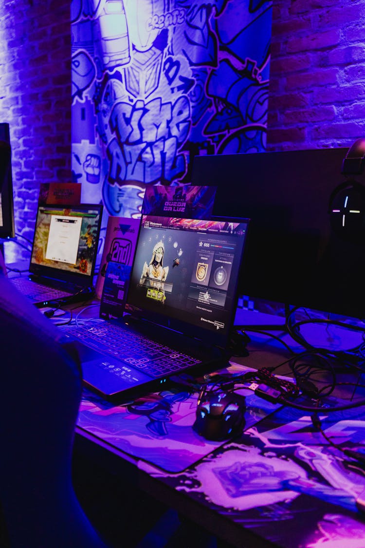 Gaming Laptops On A Desk In Purple Lighting 