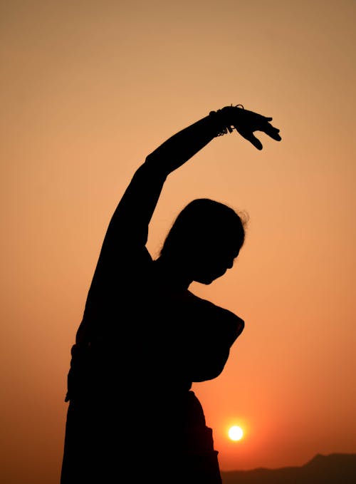 Silhouette of Woman Posing with Arm Raised
