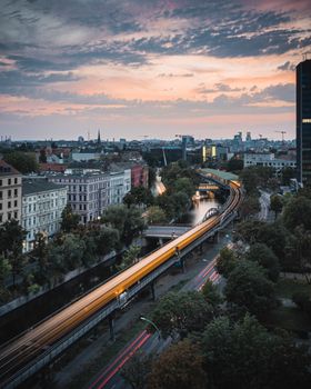 Stunning view of Berlin with a train, river, and skyline at dusk.