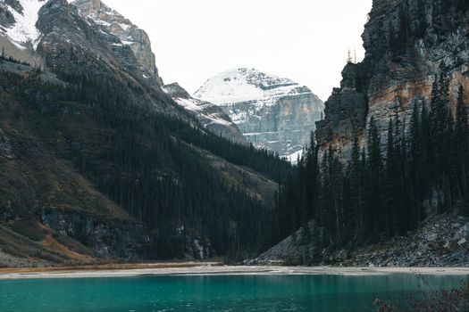 Breathtaking view of Lake Louise with surrounding mountains and evergreen trees in Banff National Park, Alberta.