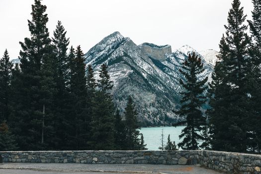 Scenic landscape of snow-capped mountains and evergreens in Banff, Canada.