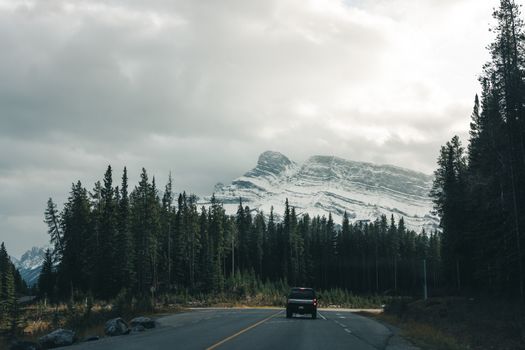 A picturesque road trip scene through Banff National Park, showcasing majestic mountains and lush forests.