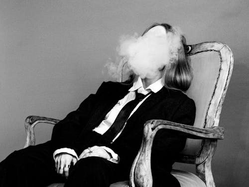 Elegant Woman Sitting on Armchair and Smoking