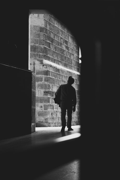 Free Dramatic black and white photo of a person silhouetted in an urban passageway. Stock Photo