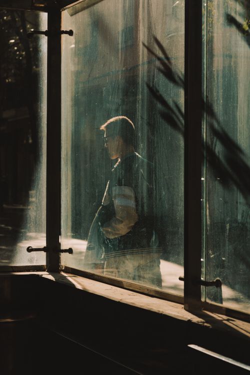 Free Artistic silhouette of a man seen through a dusty window with light and shadows outdoors. Stock Photo