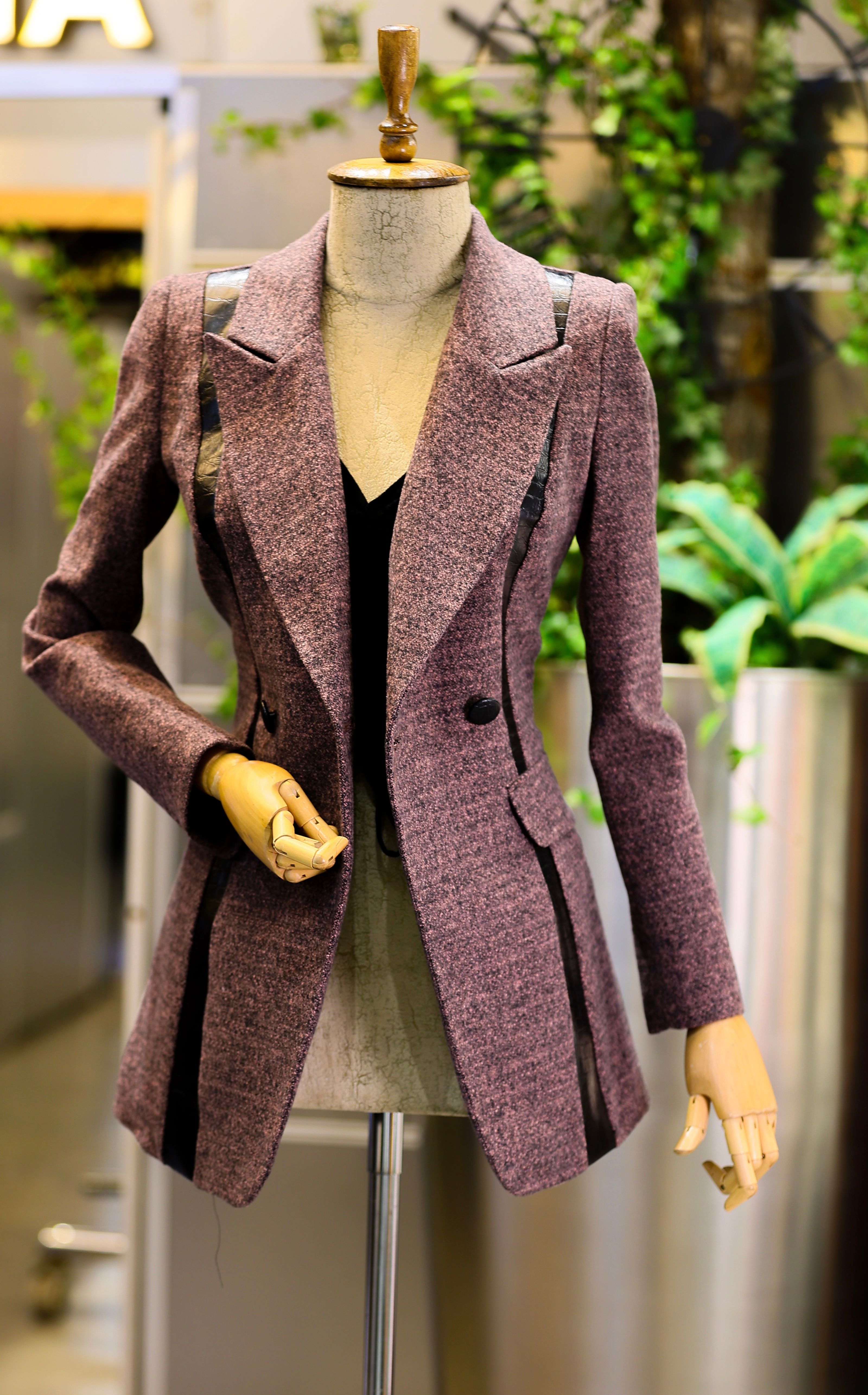 Manequim exibindo um elegante blazer rosa em um ambiente interno sofisticado.