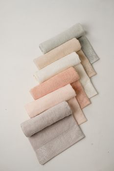 Aesthetic display of pastel towels elegantly arranged on a white background.