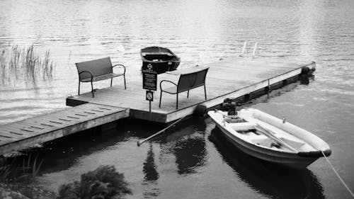 Free Boat Docked to a Wooden Pier with Benches Stock Photo