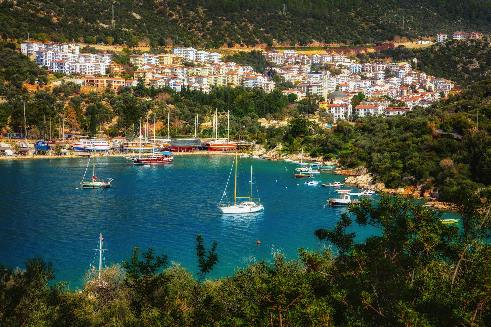 Scenic aerial view of Kaş harbor with yachts and Mediterranean coastline, Turkey.
