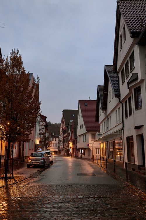 Free Cobblestone street and quaint houses under a twilight sky after rain. Stock Photo