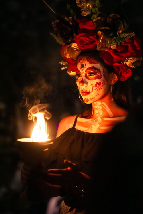 Free A woman in Day of the Dead makeup and costume holding a candlelight in the dark. Stock Photo