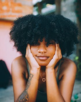 Stylish woman with afro hairstyle and nose piercing in Atlanta outdoor setting.