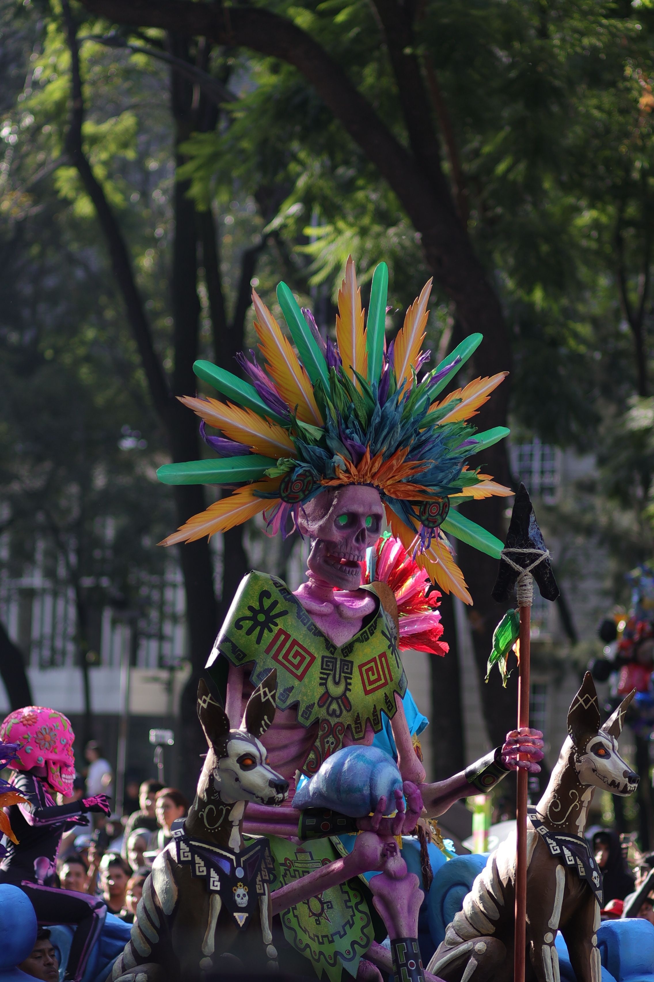 Colorful skeleton costume at a vibrant Day of the Dead parade, featuring traditional Mexican elements.