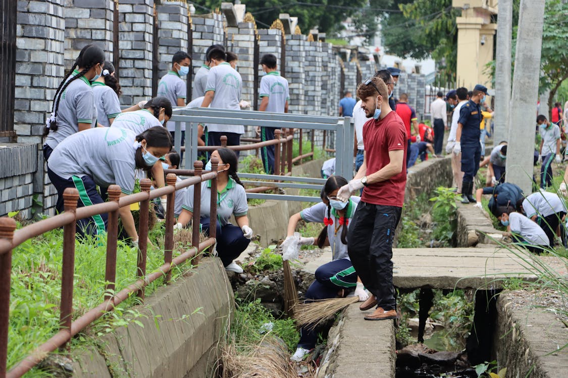 A team of volunteers working together to clean a stream, emphasizing collaboration and environmental responsibility.