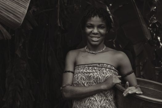Black and white portrait of a smiling woman in traditional attire.