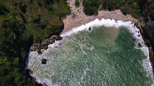 The aerial landscape of the beach and waterfall in one stunning frame, you can see many rockslides from the waterfall from the air