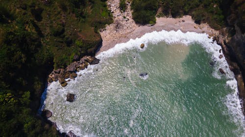 The aerial landscape of the beach and waterfall in one stunning frame, you can see many rockslides from the waterfall from the air