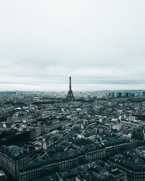 Free Aerial view of Paris with the iconic Eiffel Tower under a cloudy sky. Stock Photo