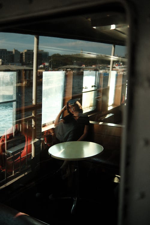 Woman Sitting at a Table on a Passenger Ship 