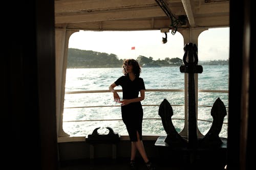Woman Leaning against a Railing on a Passenger Ship 