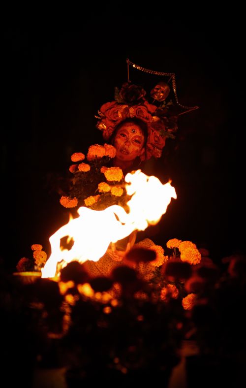 Free Floral adorned woman with painted face and flames in a Mexican Day of the Dead festivity. Stock Photo
