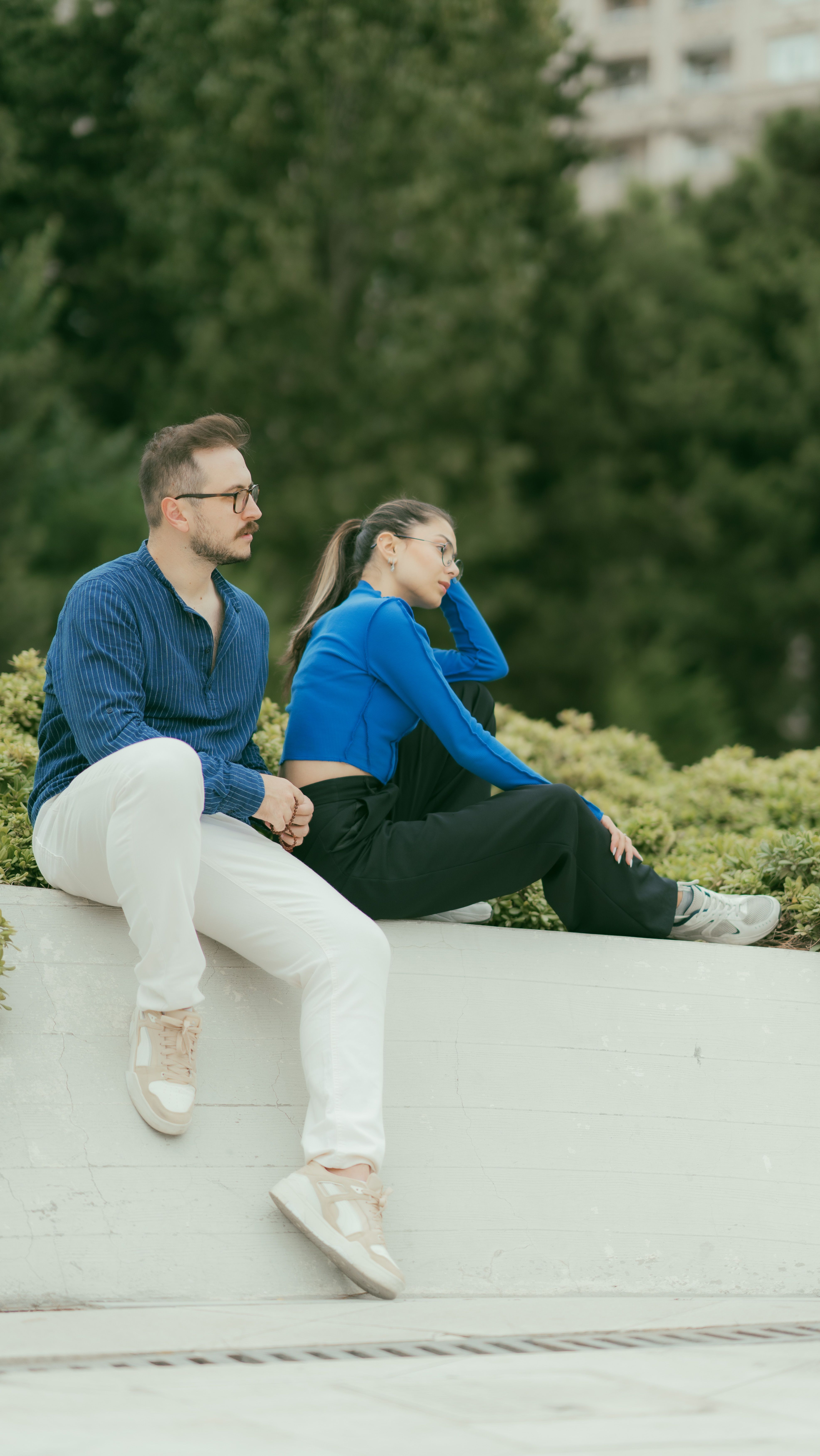 A couple enjoys a serene moment in a lush Baku park, surrounded by greenery on a summer day.