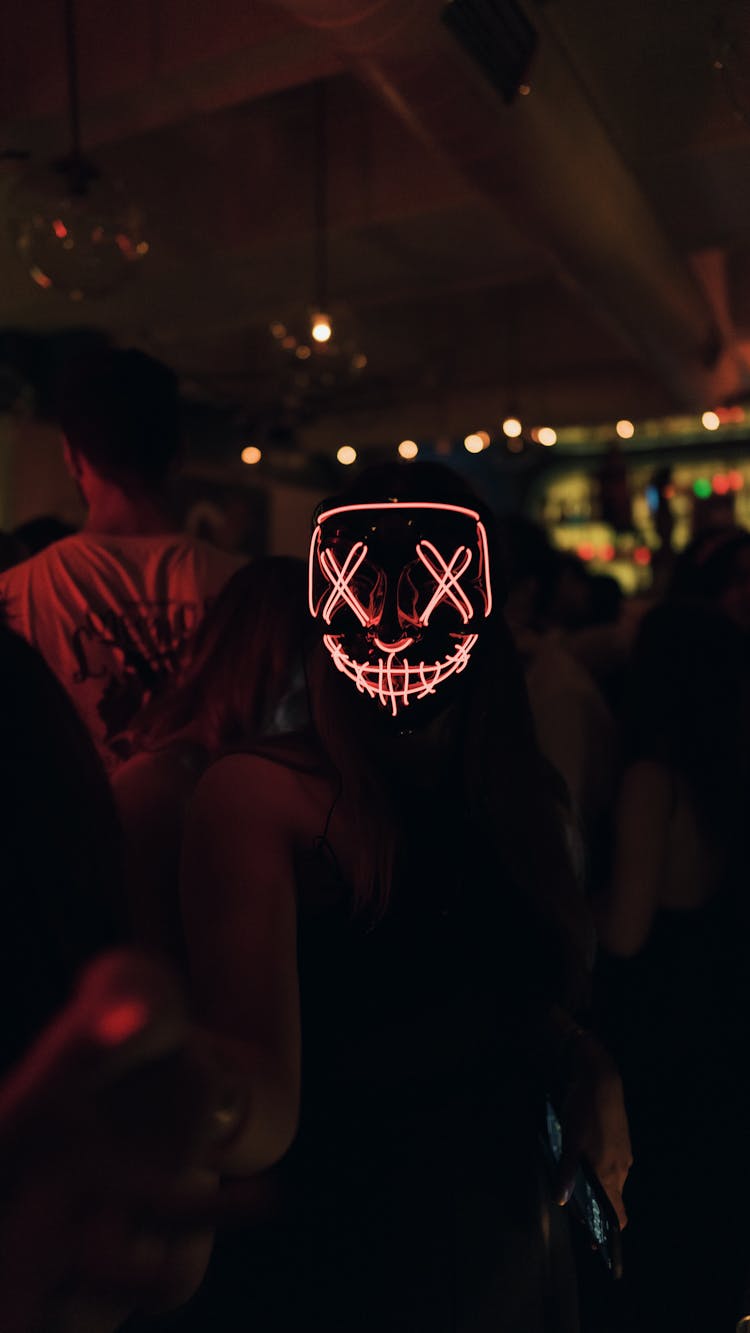 Person In Mask With Lights At Party At Night