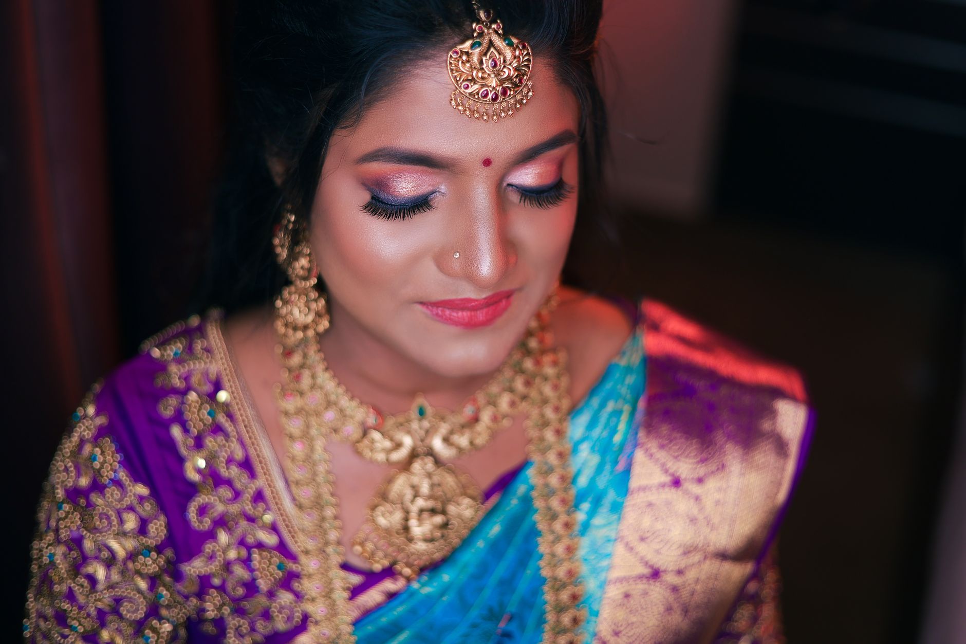 Close-up of an Indian bride wearing vibrant traditional attire and jewelry, exuding cultural elegance.