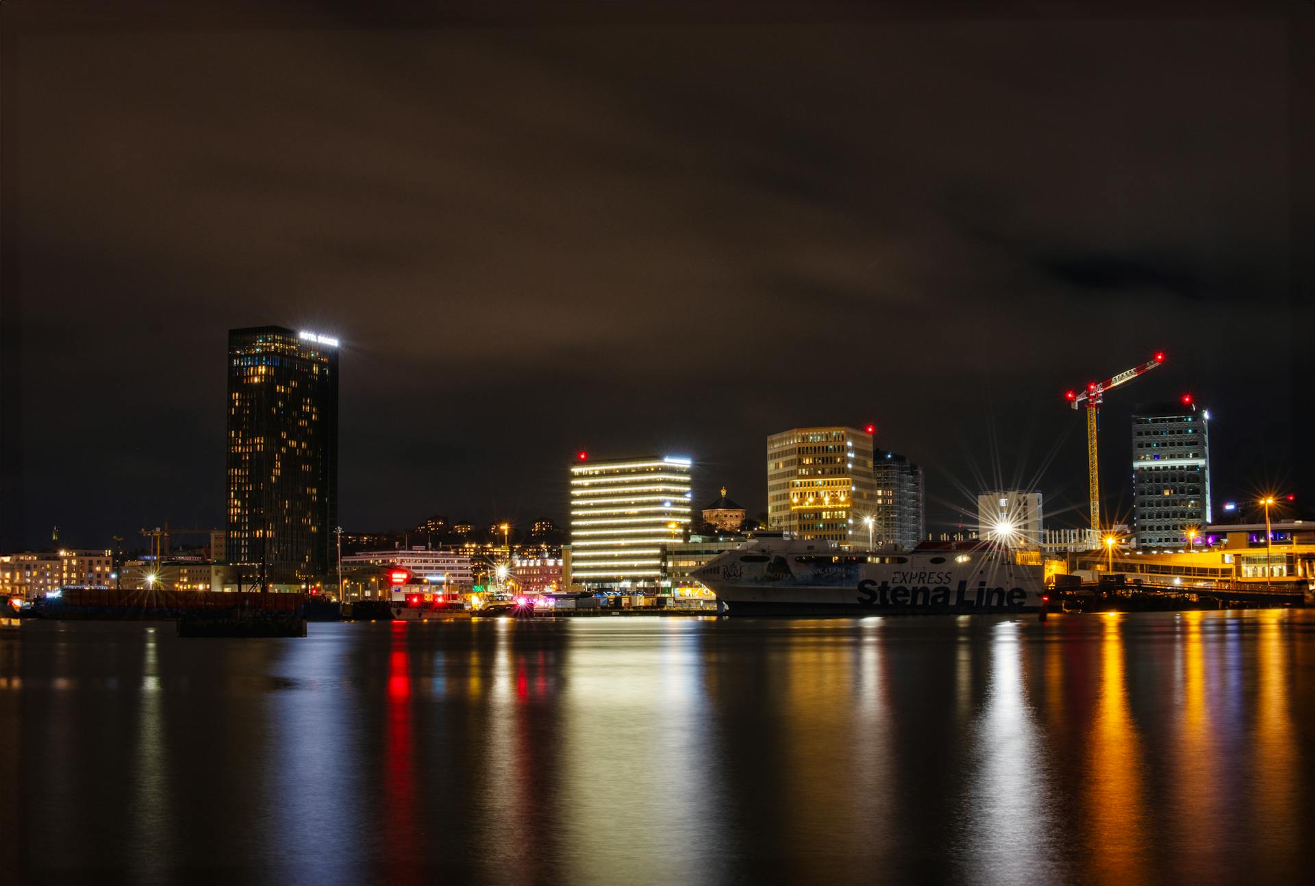 Illuminated cityscape of Göteborg with Stena Line ferry at night.