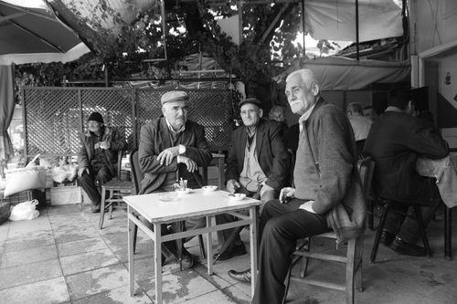 Free Black and white image of elderly men socializing in a Bergama café. Stock Photo