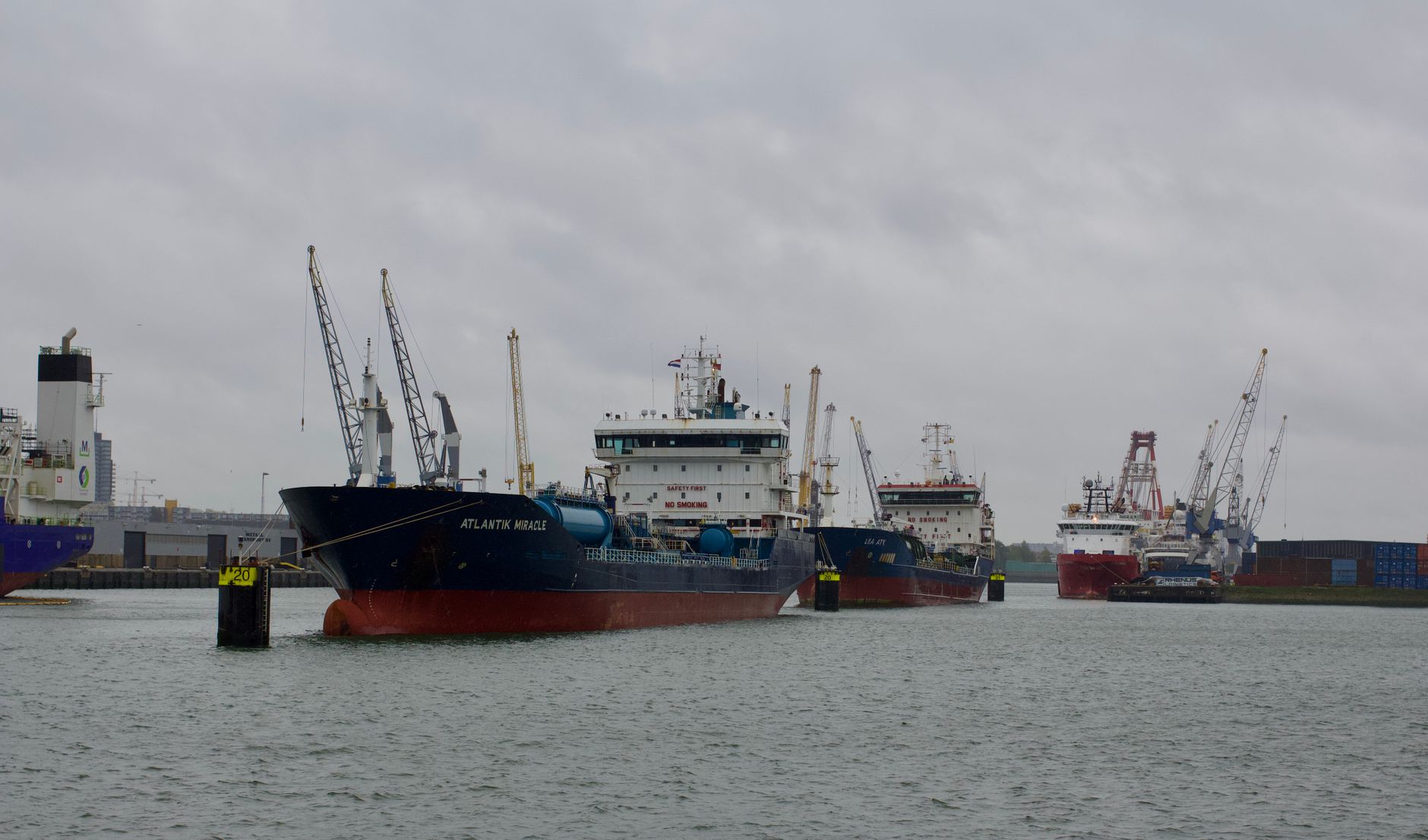 Cargo ships moored at a busy port under cloudy skies, showcasing global maritime trade.