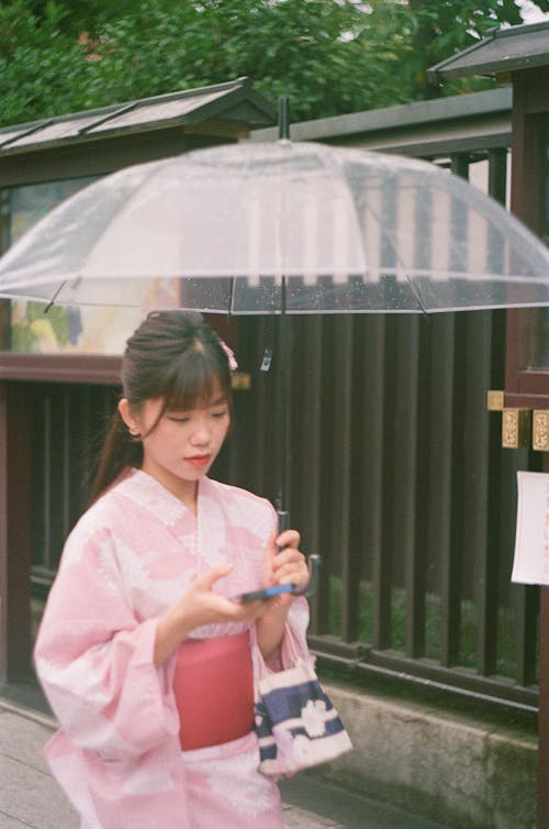 Young Woman Walking Outside with an Umbrella 
