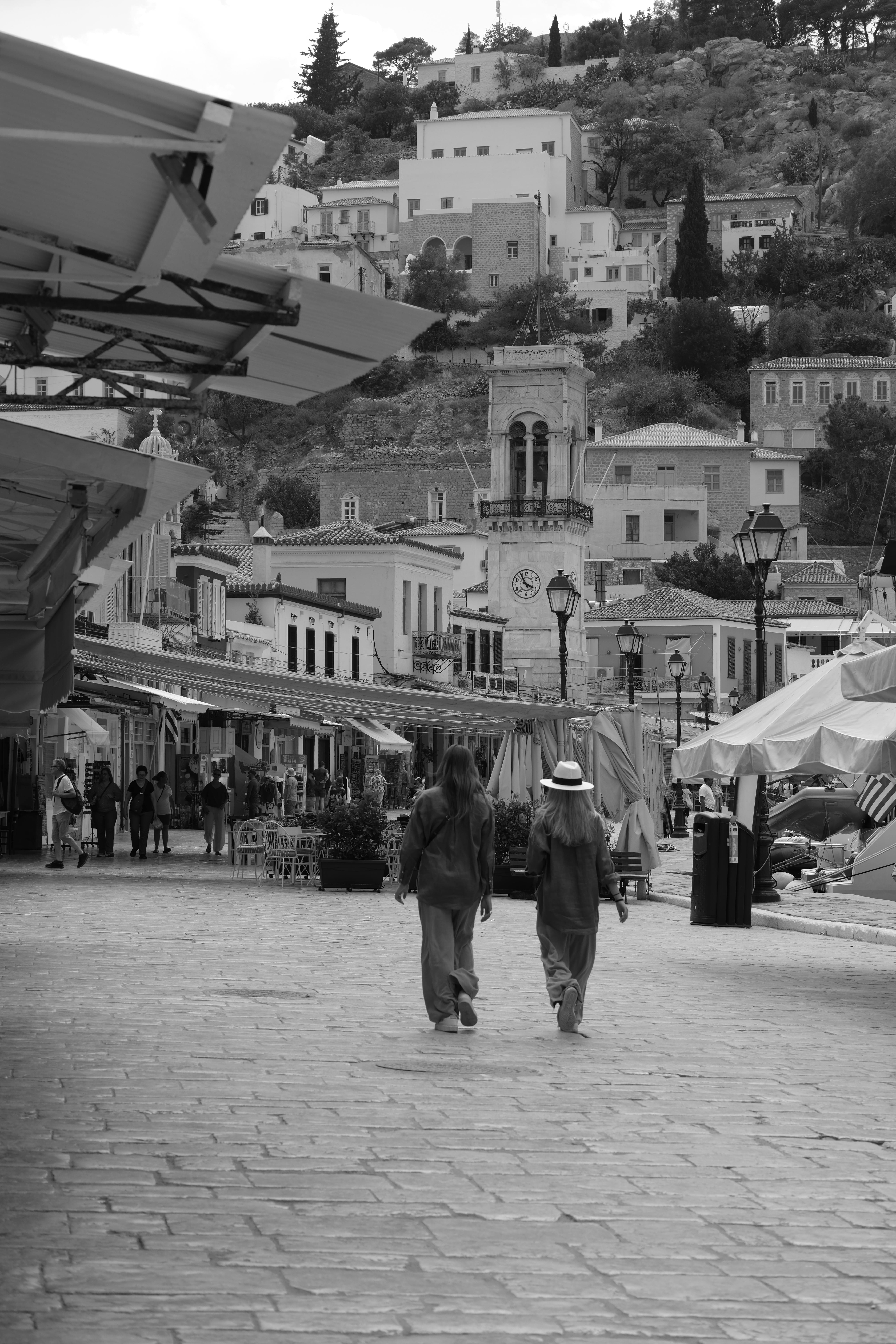 A scenic black and white view of people strolling through a quaint town street.