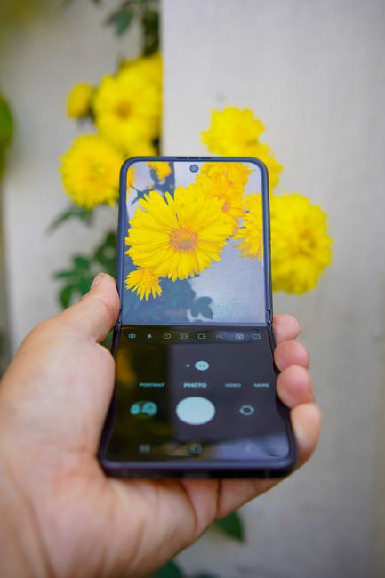 Katlanabilir telefon alırken ekran ve menteşe kontrolü yapan kullanıcı