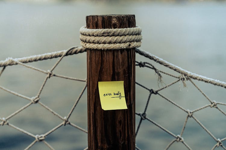 Sticky Note On Wooden Post