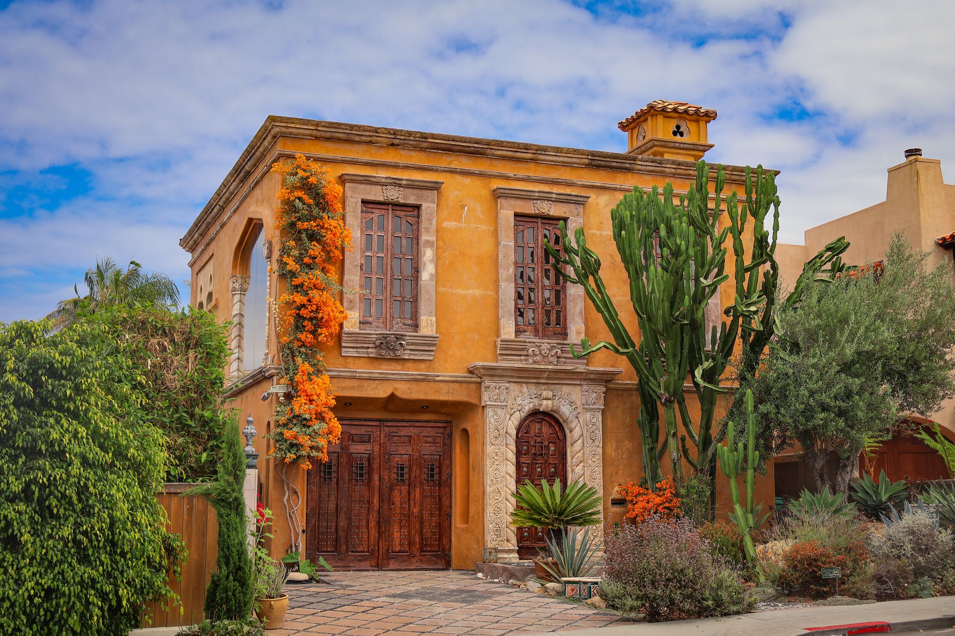 Elegant Mediterranean-style villa in San Diego with freshly painted exterior and lush tropical landscaping