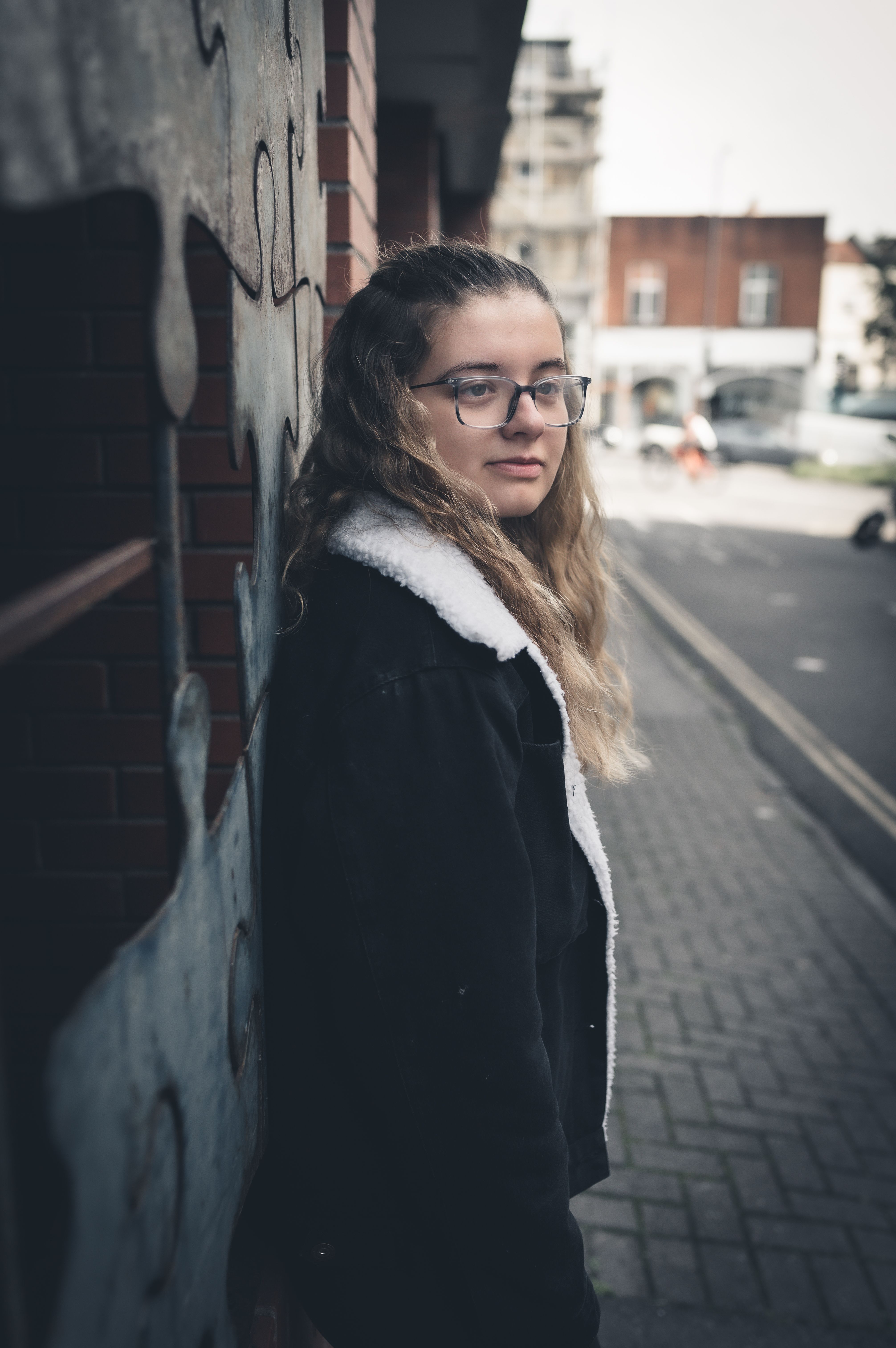 Young Woman in a Black Jacket Standing on the Sidewalk · Free Stock Photo