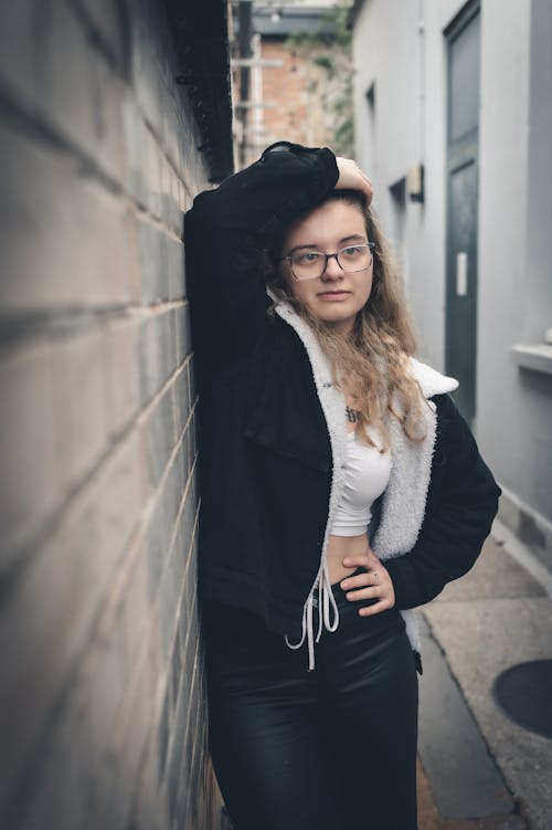 Blonde Woman in Eyeglasses Standing in Alley