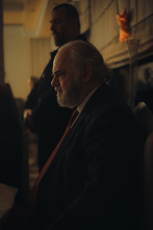 Elderly Man in Suit Sitting