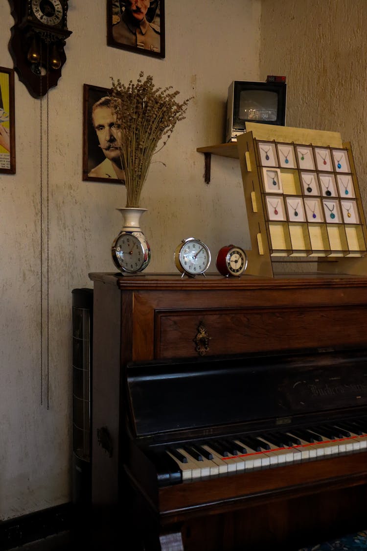 Alarm Clocks, Box With Pendants And Plants In Vase On Vintage Piano