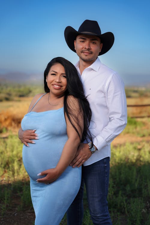 Portrait of Man in Cowboy Hat and Pregnant Woman in Blue Dress