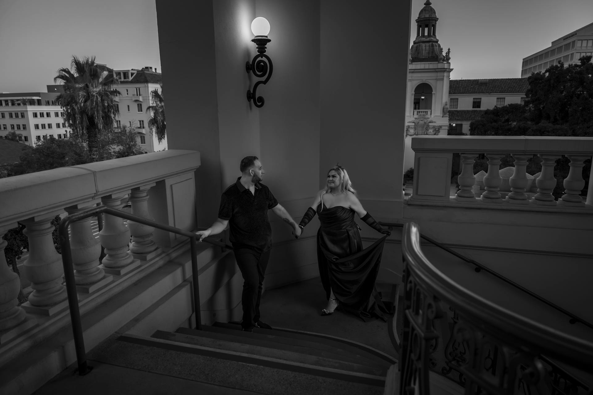 A stylish couple ascends stairs at a Pasadena venue, enhancing elegance and charm.