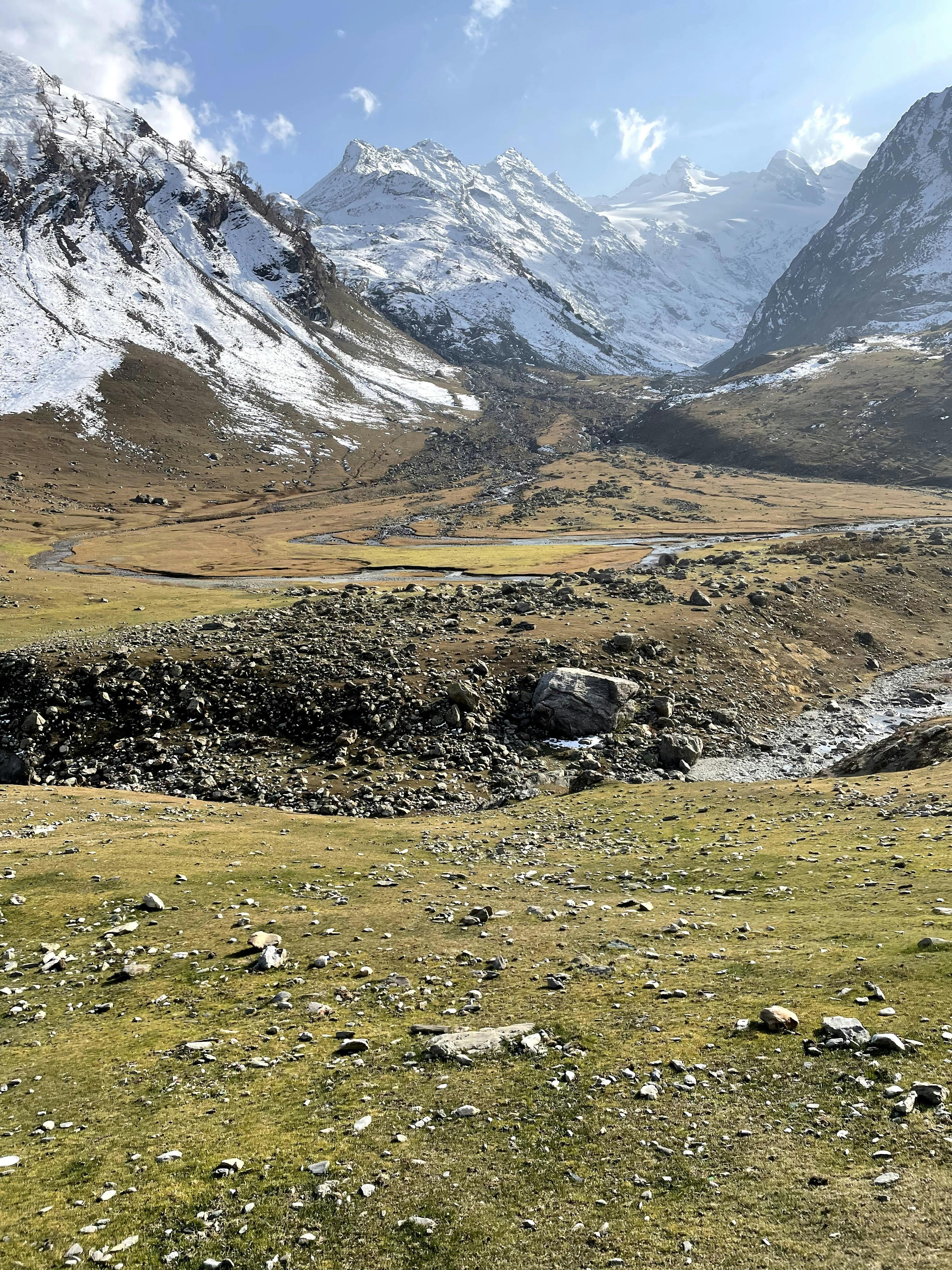 Prescription Goggle Inserts - Explore a serene mountain valley with snow-capped peaks and rocky terrain under a clear blue sky.