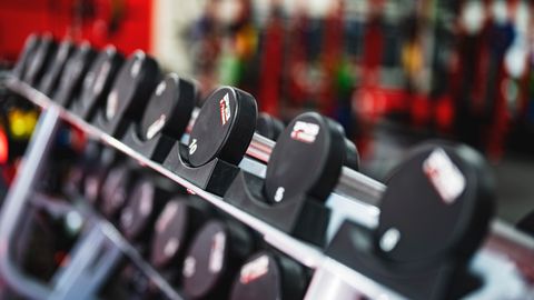 Close-up view of dumbbells in a modern gym setting, emphasizing fitness and training.