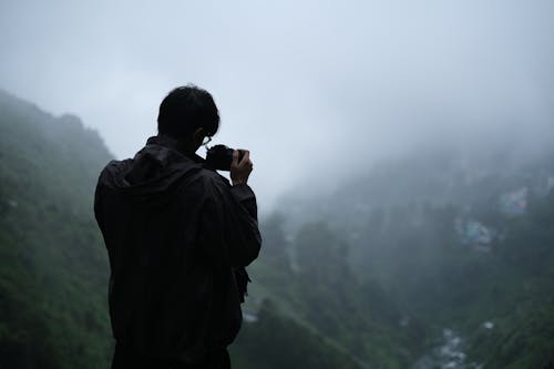 Photographer Taking Photos of Fog Covered Valley