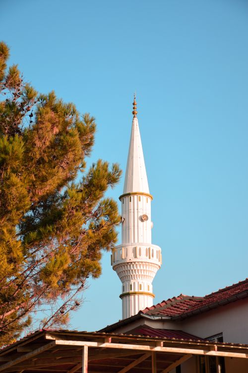 Free A beautiful white minaret next to a cypress tree under a clear blue sky in Malatya, Türkiye. Stock Photo