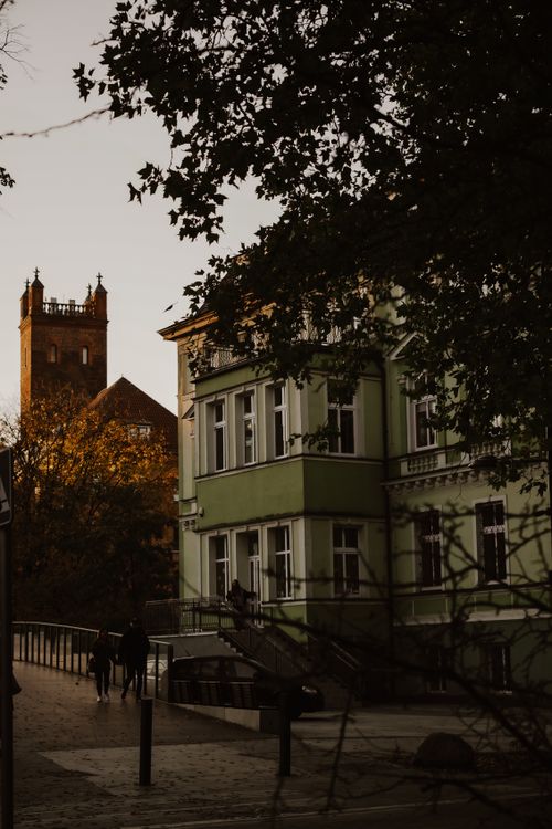Free Serene evening street view showcasing classic architecture and a distant tower. Stock Photo