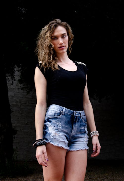 Young Woman in a Black Top and Denim Shorts 